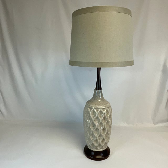 Offering a stunning Mid-Century Tall Ceramic and Walnut Table Lamp. The ceramic body features a detailed geometric design...