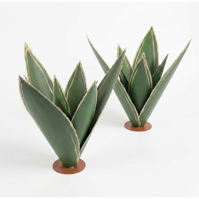 A striking pair of vintage-inspired botanical sculptures meticulously handcrafted from sheet metal, expertly capturing the...