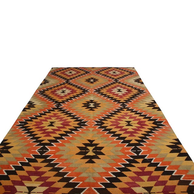 Hand woven in Turkey originating between 1950-1960, this Vintage mid-century 6x10 wool kilim hails from the town of Mut...