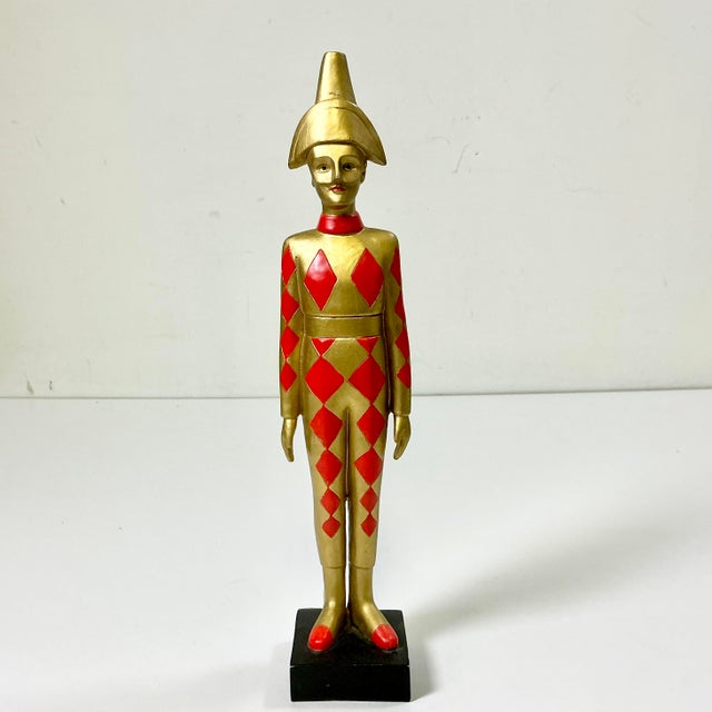 We love this guy. He’s both sophisticated and whimsical. This tabletop figurine is a Jester decked out in a hold and...
