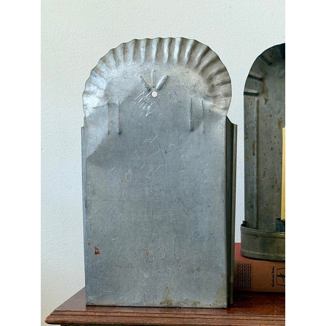 A set of three antique primitive tin wall sconces with beautifully simple hand-formed construction and scalloped arched...