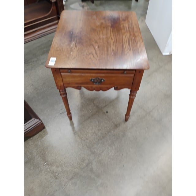 Vintage oak side table/end table by Thomasville. Having a rectangular top, pullout tray, and a single dovetail drawer with...