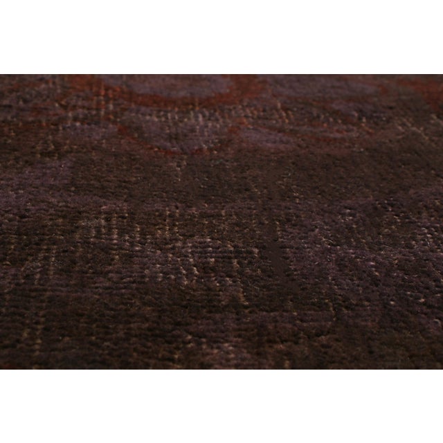 Originating from India, this hand knotted wool rug employs a deep purple background with a unique combination of muted and...