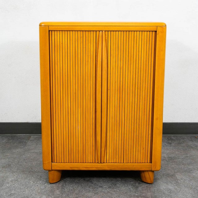 Stylish tambour door utility cabinet by Heywood Wakefield. This unique compact design features an adjustable shelf within....