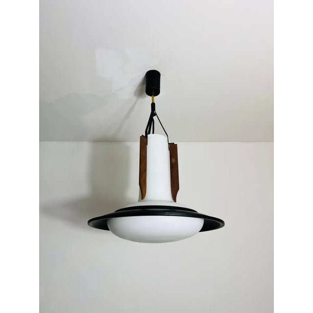 This elegant italian ceiling lamp from the 1960s is a stunning example of mid-century modern design. The centerpiece is a...