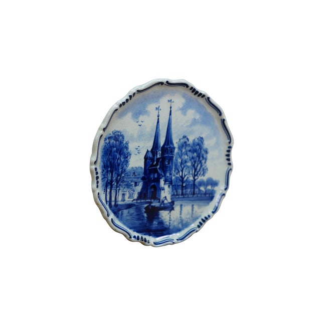 An early 20th Hand Painted Delft Wall Hanging Plate. Features a river scene in Delft, South Hollands showcasing the...