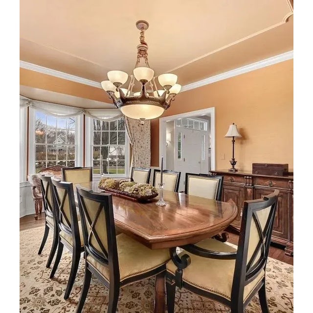 A vintage monumental-sized custom dining table with a planked sunburst and banded top, deep apron and a pair of heavy,...