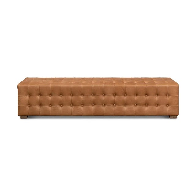 This bench is covered in luxurious brown leather with a tufted design on its tops and sides. It sits on oak legs in a...