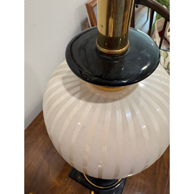 Elegant black and off white ceramic lamp from the 1960s made by Ethan Allen. Gold accented black trim and subtle...
