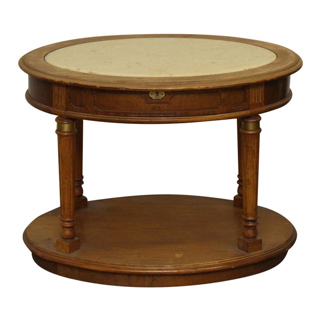 Oval shaped wooden side table with a white marble inset top. This piece is set on four column shaped legs. Good condition...