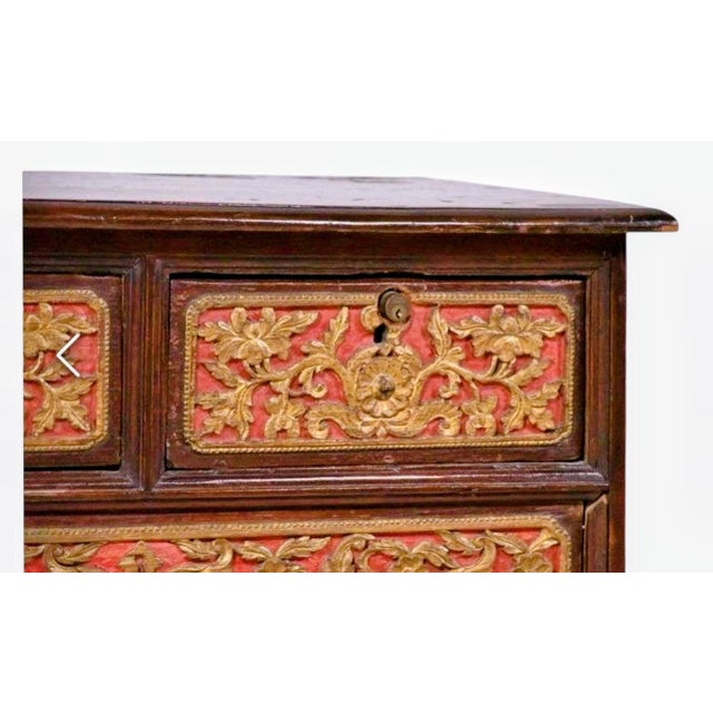 Ornate 19th C Chinese wooden chest has hand-carved floral and scrollwork panels with a red and gold gilt finish. This...