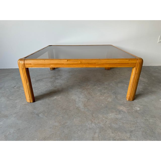 A gorgeous 1970's Vintage Coastal waterfall edge bent rattan square coffee table with inset beveled smoked glass top....