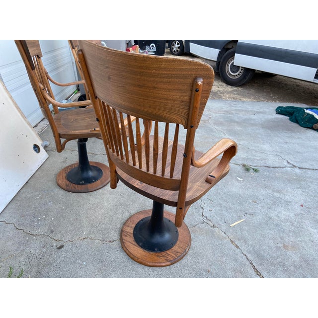 This set of 3 antique oak juror chairs from the early 1900s features a cast iron base and a brown varnished finish. Fully...