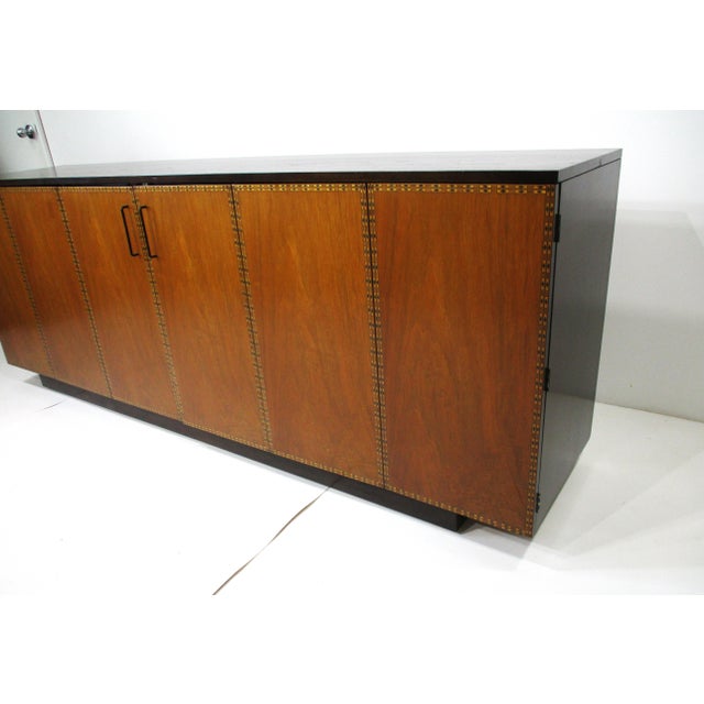 A rare exceptionally stunning mahogany credenza or sideboard with double tri folding doors having thin black pulls. The...