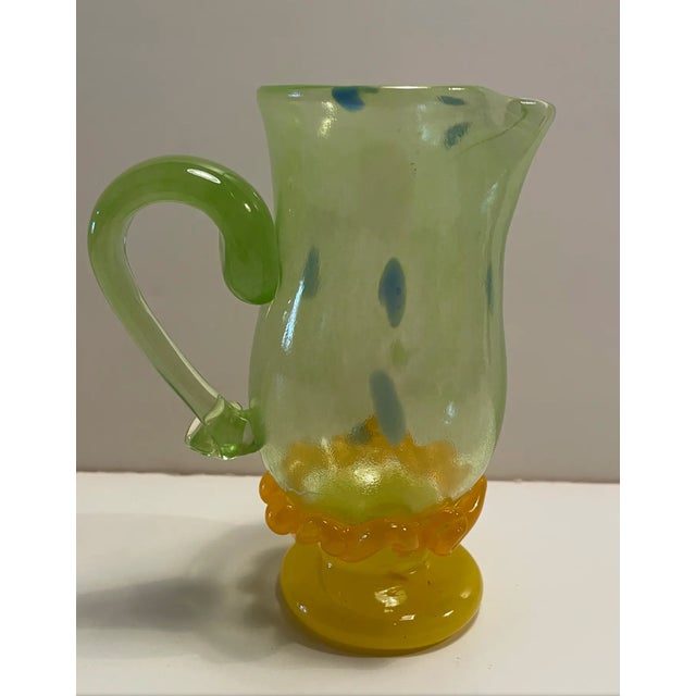 A green, yellow, and orange small blown glass pitcher. Signed "Arien" and was found in central North Carolina. Many more...