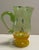 A green, yellow, and orange small blown glass pitcher. Signed "Arien" and was found in central North Carolina. Many more...