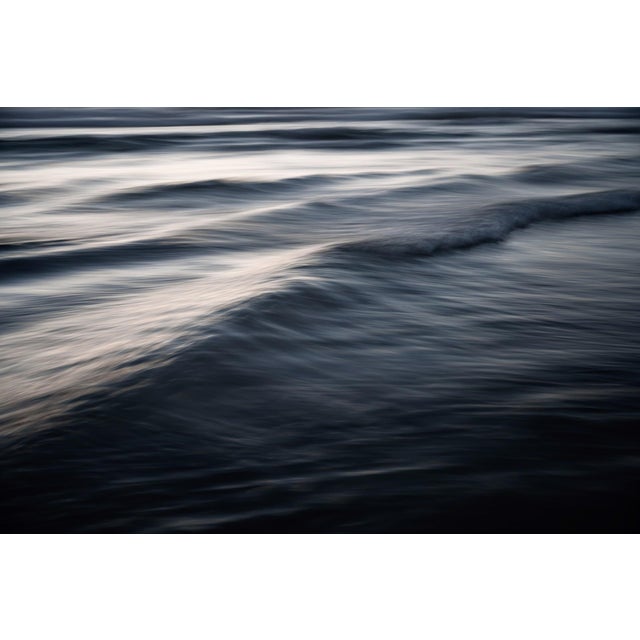 This photograph captures the fluidity and grace of ocean waves, emphasizing their rhythmic movement and interplay of...