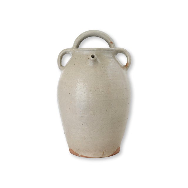 Late 19th century French glazed terracotta jug in a tall provincial form with generous double handles rising from the...