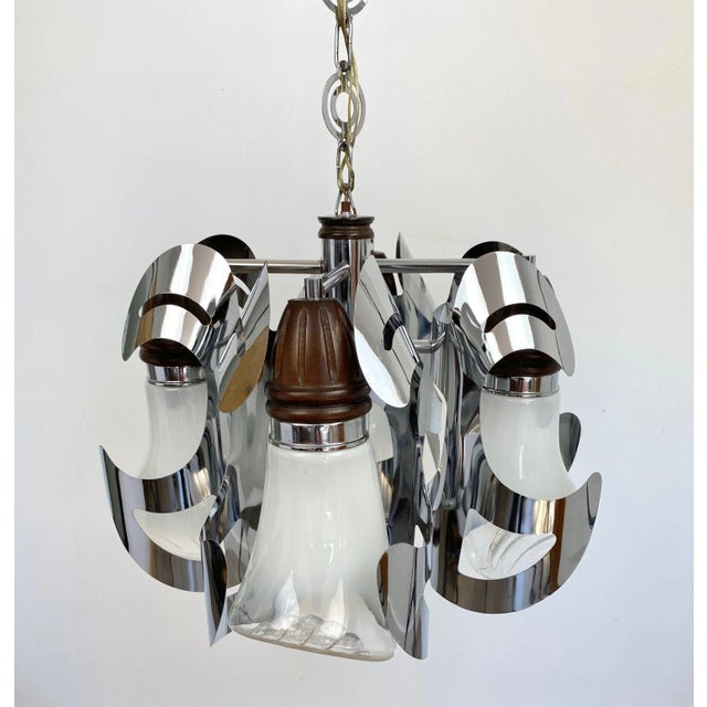 Chandelier in chrome, wood and Murano glass, four-light. Made by the Italian Mazzega, Italy, circa 1970. This piece is...