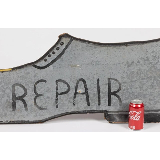 AMERICAN FOLK ART PAINTED WOOD AND TIN TRADE SIGN, single sided, in the form of a shoe, marked "REPAIR". Mid 20th century....