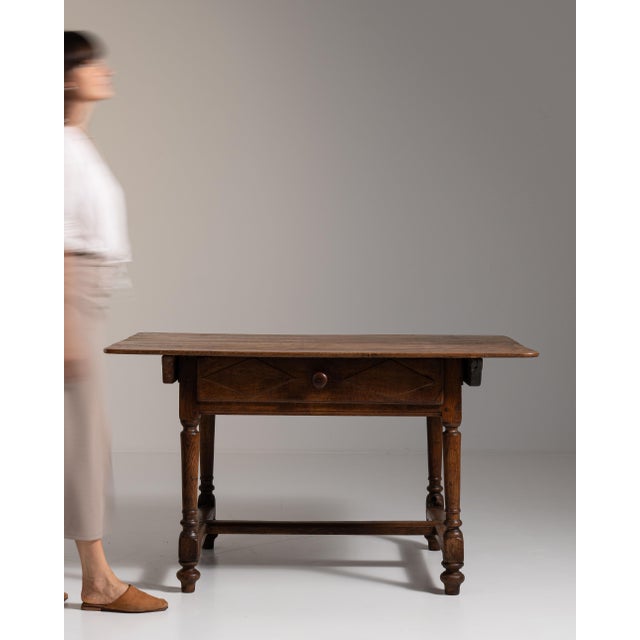 This 19th century oak table with single drawer from France is made in dark oak with a single drawer, turned legs and a low...