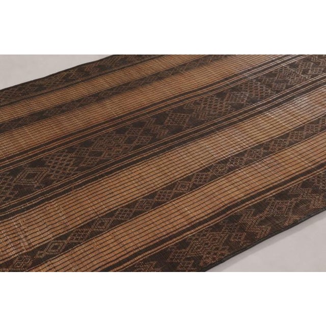 Made with handwoven reed and camel leather in Mauritania circa 1950-1960, this 6x9 vintage Tuareg mat is an exceptional...