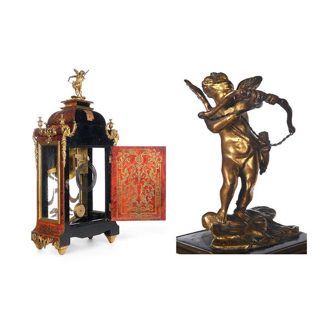 Mechanical clock in inlaid wood. Antique decorative object in wood and bronze. Has a small gilt bronze sculpture of cupid...
