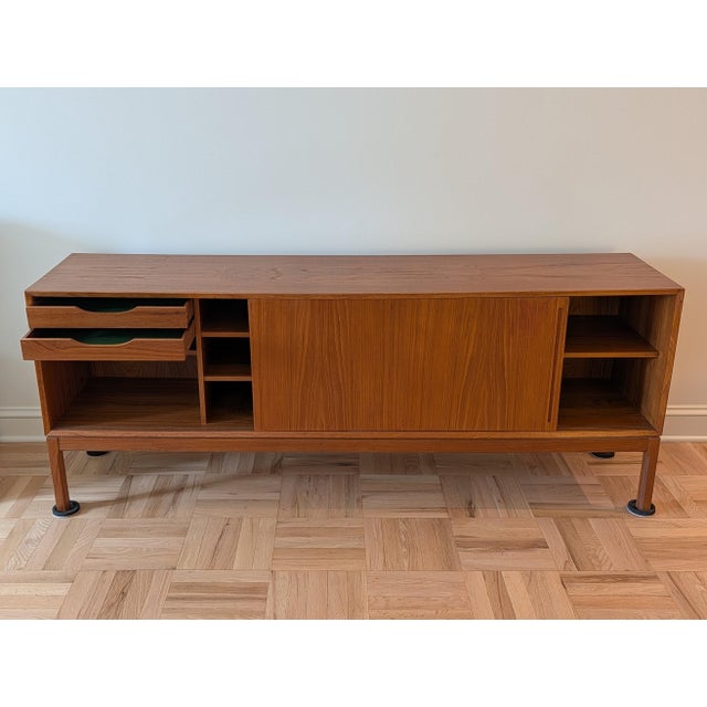 Beautiful and substantial vintage mid-century Danish modern teak credenza/sideboard with two sliding doors. One long...