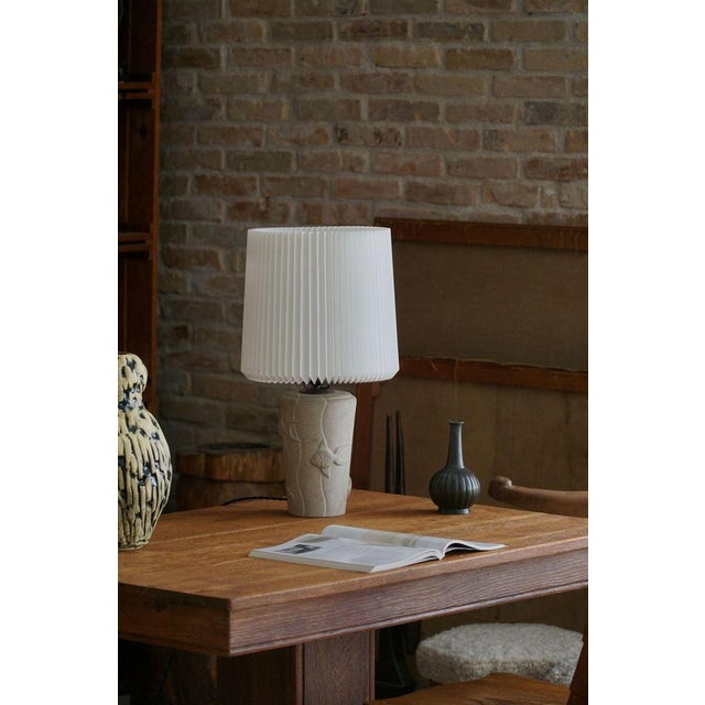 A charming mid century table lamp in stone. Made in France in the 1970s. The lamp features a unique stone base adorned...