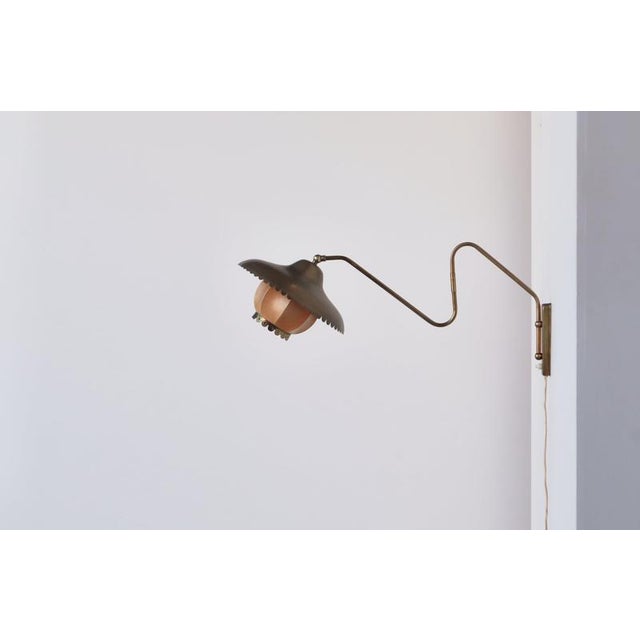 A beautifully preserved danish 1940s brass swing lamp, attributed to bent karlby for lyfa, retaining its original shade in...