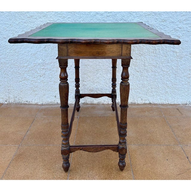 This refined Spanish games table from the 1920s features a beautifully carved oak frame with sculpted edges and elegant...