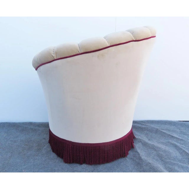 A Hollywood regency style Club Chair, curved tapered design back, upholstered in an off white mohair with burgundy piping...
