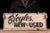 Double-sided painted wood advertising sign reading "Bicycles New & Used" in bold black lettering against a cream ground....