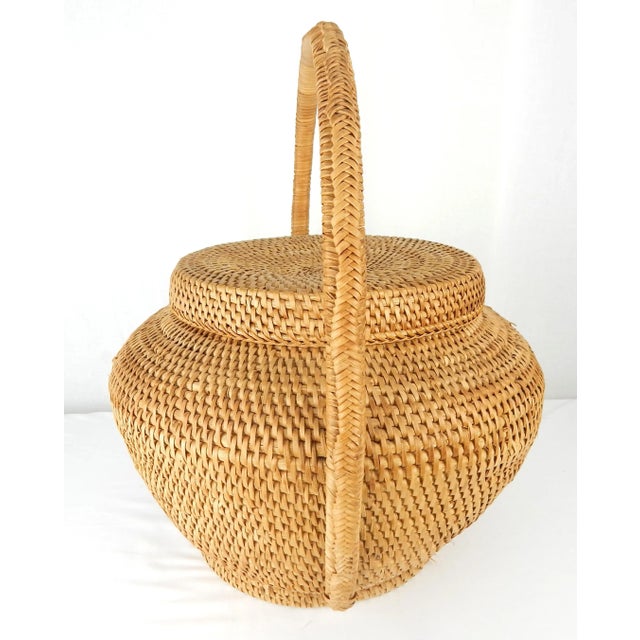 Charming hand-woven basket with large handle and removable lid. No maker's mark. Good vintage condition with minor...