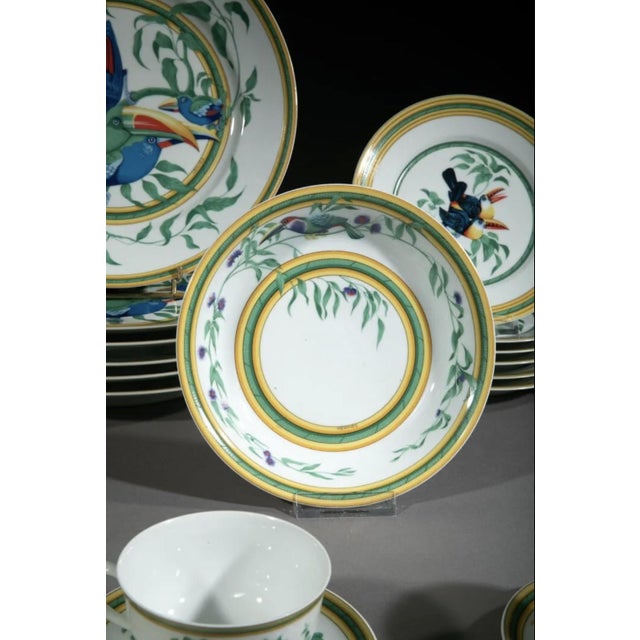 Hermes & limoges "les toucans", a 1986 design. A 30-piece polychrome glazed porcelain dinnerware set featuring perched...