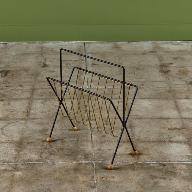 American made wire magazine rack by New York-based designer Tony Paul. The rack has a black wrought iron skeletal frame...