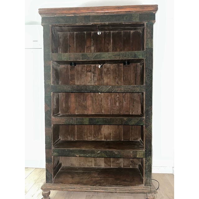 Beautiful Indian wood bookcase with detailed hand-carved decorative panels and touches of green, red, and natural wood...