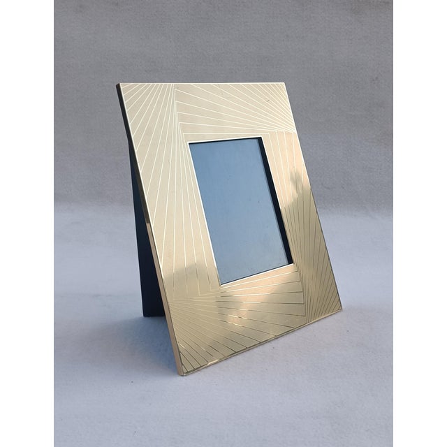 Gold-plated metal photo frame decorated with geometric lines, back support with wallet clasp. Made in Italy in the...