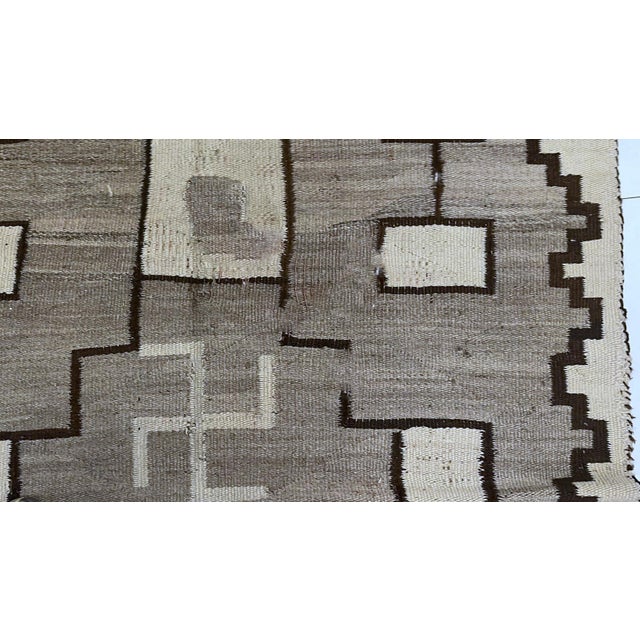 This handmade antique Native American Navajo rug from the early 1900s is a powerful testament to indigenous artistry and...