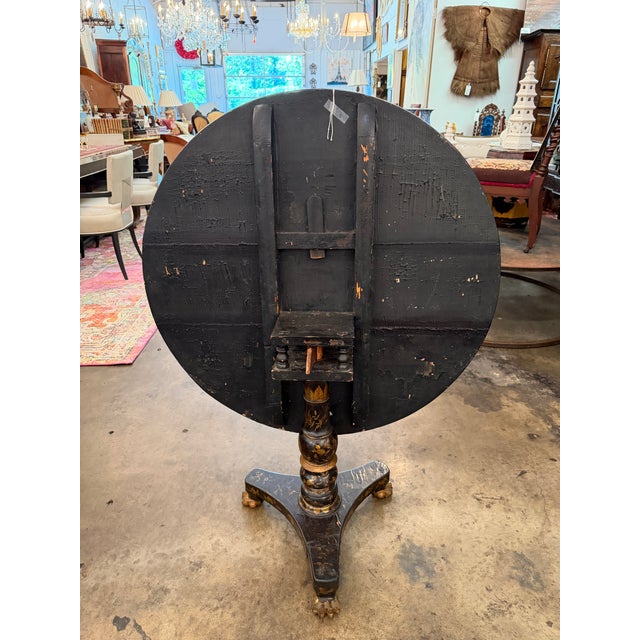 An exceptional 19th-century Chinese Export black lacquer and gilt decorated tilt-top guéridon center table. This striking...