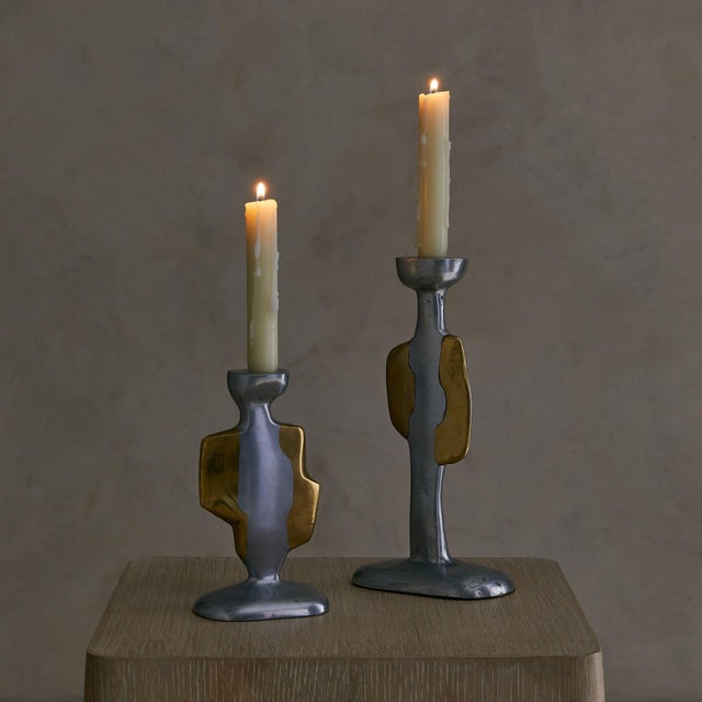 A pair of hand-cast candleholders by David Marshall, dating to the 1970s. The aluminum stems rise from softly rounded...