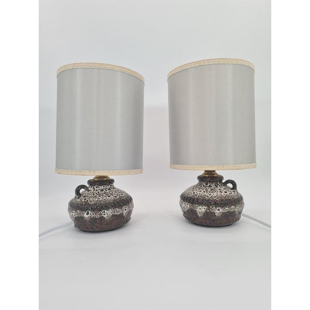 An original pair of table lamps made of glazed ceramic, produced in West Germany in the 1970s. Solid, low bases with a...