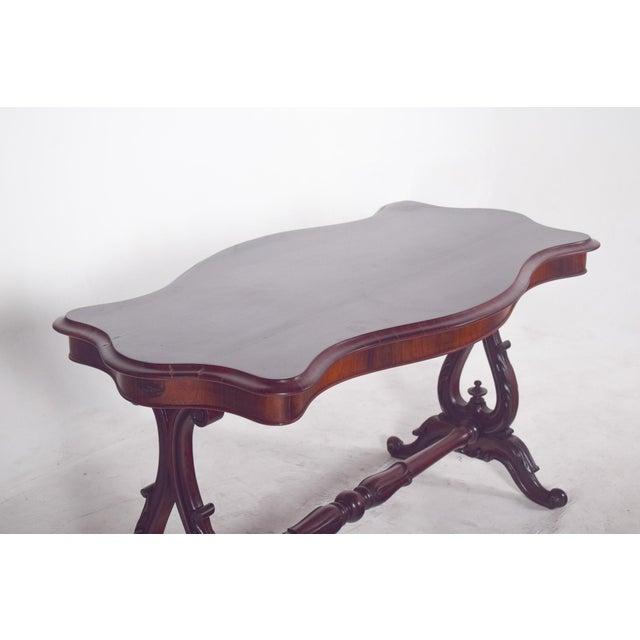 Victorian coffee table in rosewood. The top has jagged, gently rounded contours, revealing the refined craftsmanship...