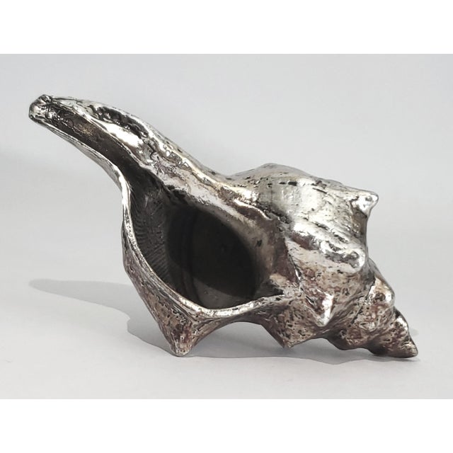 Offering a vintage conch shell dipped in a silver alloy, circa Late 20th Century. This gorgeous small seashell is a REAL...