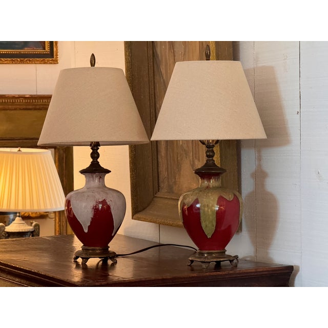 Pair of table lamps converted from Sang de Boeuf glazed vases with rich oxblood red and dramatic drip glaze. Each sits on...