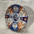 19th Century Japanese Imari plate. Hand painted with red orange, cobalt blue, and green on a white ground. The central...