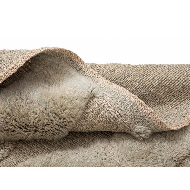 Sophisticated hand-knotted wool rug with a Nomadic Taupe base, enhanced by plush textured layers forming an abstract maze...