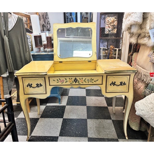 Vintage John Widdicomb painted vanity/desk. Hand-painted in a soft yellow with floral detail. The center top flips up to...