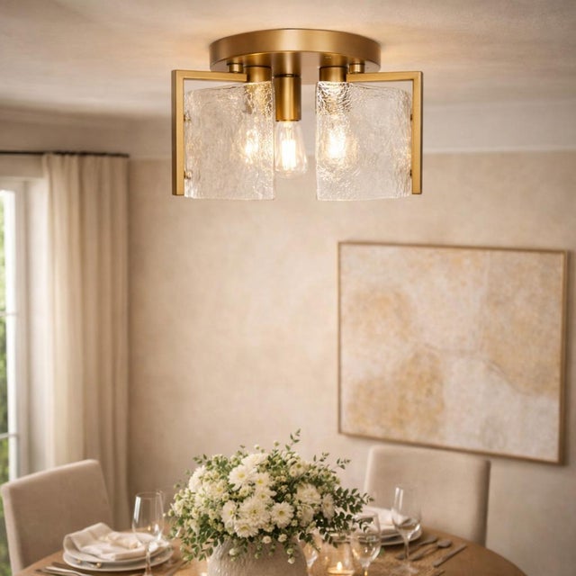 Architectural contemporary semi-flush mount ceiling light featuring a warm brass-tone frame and sculptural curved textured...
