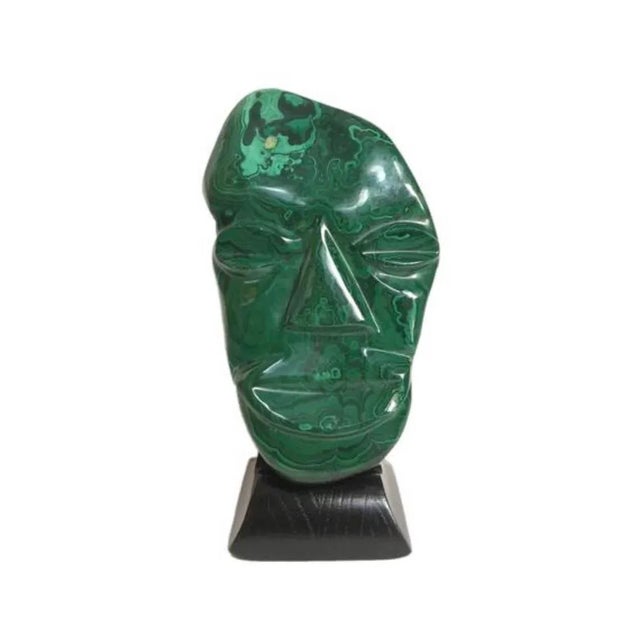 Fabulous find. Hand carved malachite mask sculpture on refinished wood base. It could easily be used as a wall hanging....